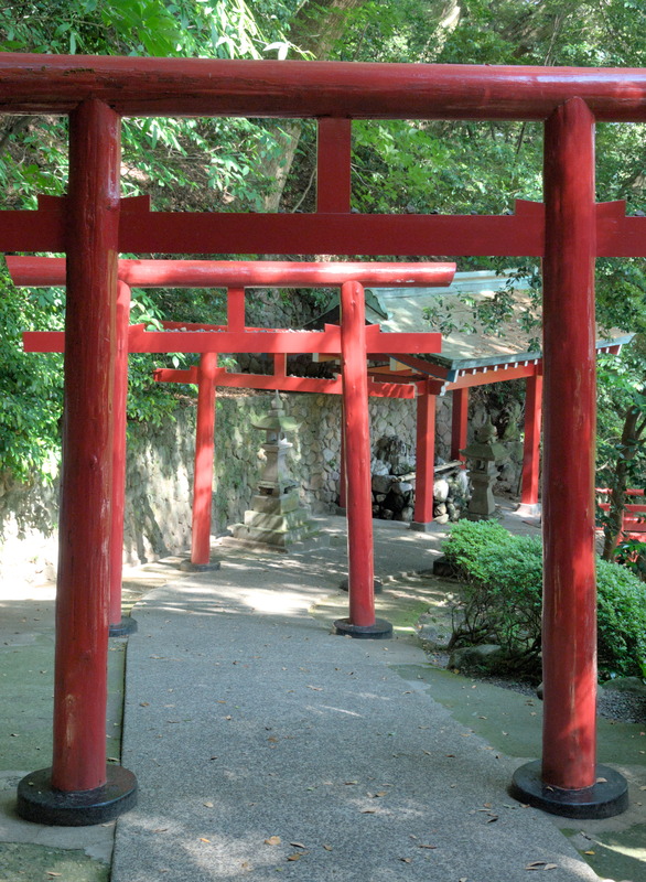 Une allée de torii avec des étendards sur le côté
